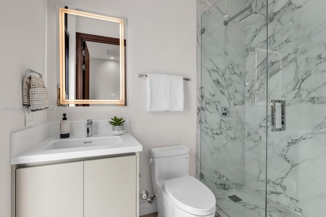 full bath featuring a marble finish shower, vanity, and toilet