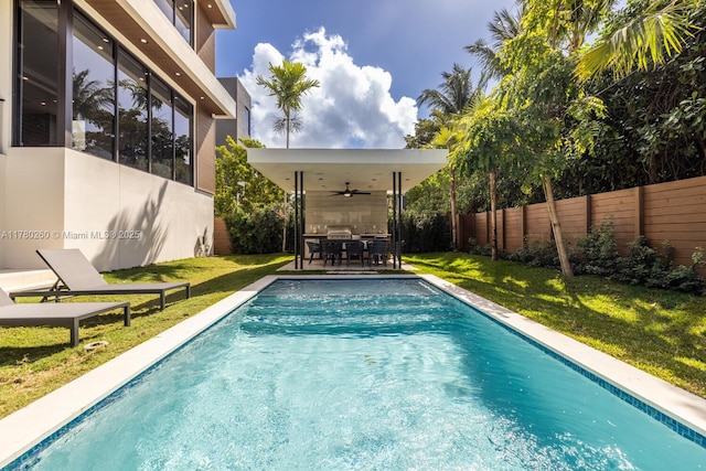 view of swimming pool featuring outdoor dining area, a ceiling fan, a fenced backyard, and a yard