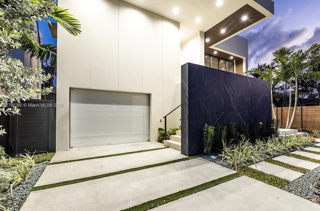 garage with fence and driveway