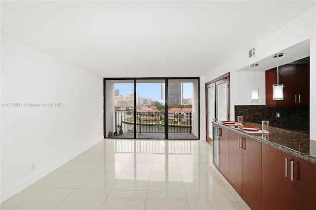 kitchen with visible vents, baseboards, decorative light fixtures, and decorative backsplash