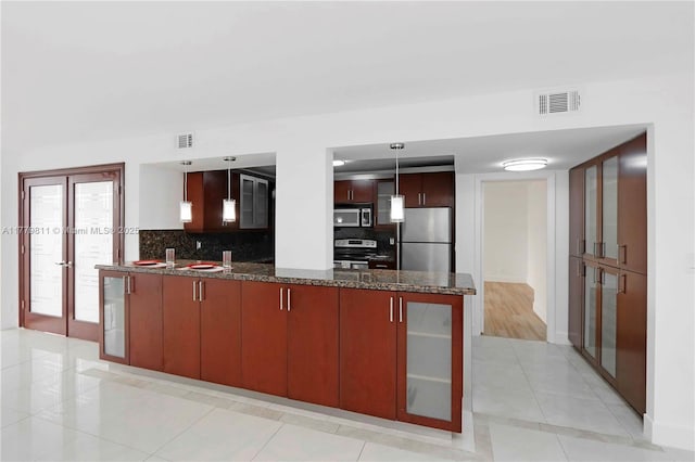 kitchen featuring a peninsula, visible vents, appliances with stainless steel finishes, light tile patterned flooring, and decorative backsplash