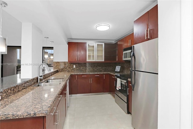 kitchen with a peninsula, a sink, backsplash, and stainless steel appliances