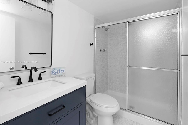 full bathroom featuring toilet, a shower stall, and vanity