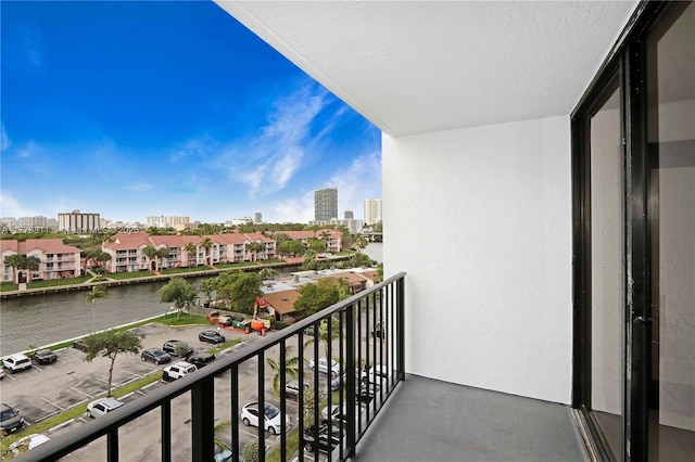 balcony featuring a water view and a city view