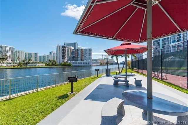 view of home's community featuring a water view, fence, and a city view