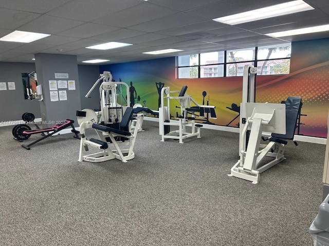 exercise room with a drop ceiling and baseboards