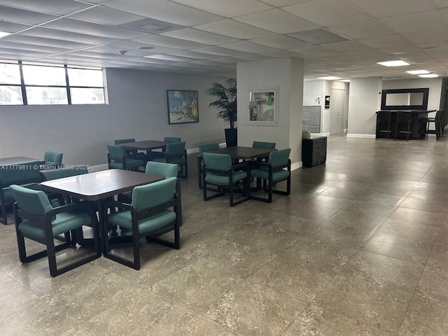 dining room featuring a drop ceiling and baseboards
