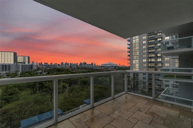 balcony at dusk featuring a view of city
