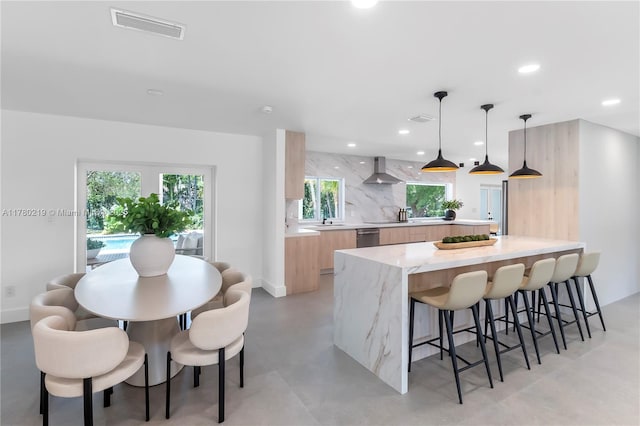 7551 SW 109th Ter, Pinecrest, FL 33156 - kitchen featuring modern cabinets, wall chimney range hood, a breakfast bar area, recessed lighting, and backsplash