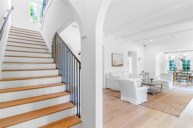 1225 N Greenway Dr, Coral Gables, FL 33134 - stairs featuring wood finished floors, arched walkways, a chandelier, and recessed lighting