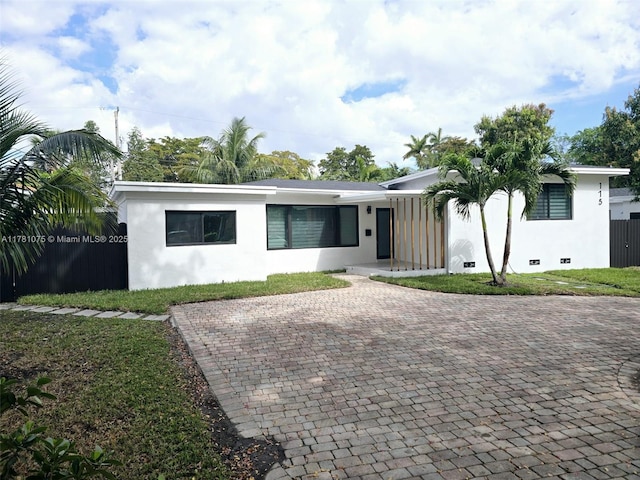ranch-style home with a front yard and stucco siding