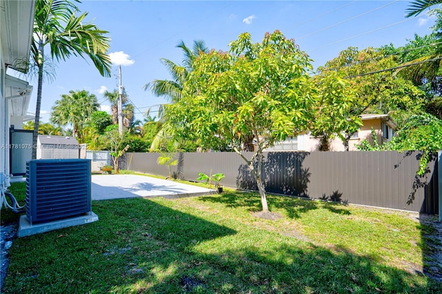 view of yard with a patio, a fenced backyard, and central AC unit