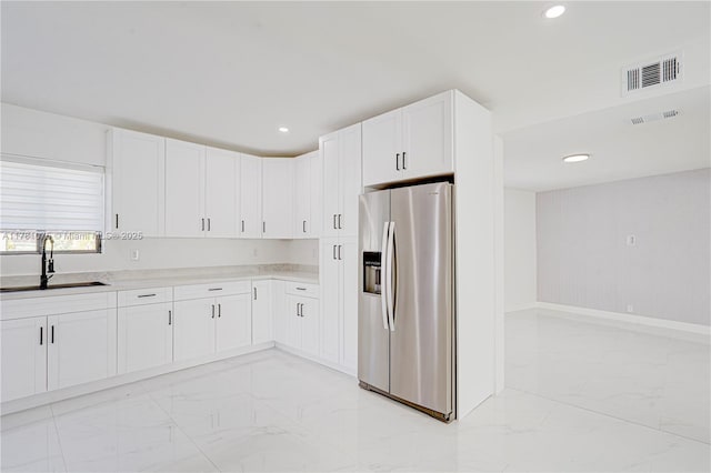 kitchen with recessed lighting, stainless steel fridge with ice dispenser, marble finish floor, a sink, and visible vents