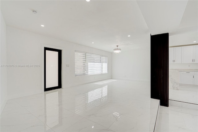 empty room with a chandelier, recessed lighting, and marble finish floor
