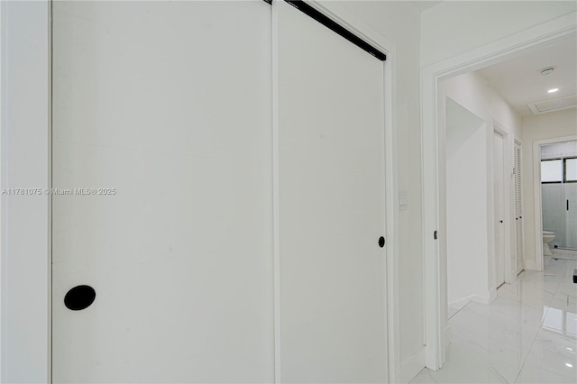 corridor with marble finish floor and baseboards