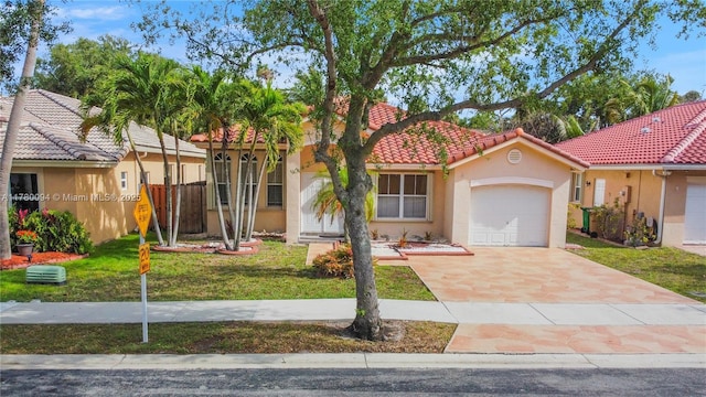 view of front facade featuring a tiled roof, stucco siding, a front lawn, a garage, and concrete driveway