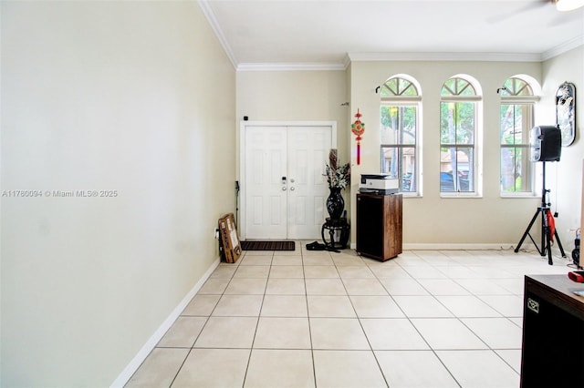 foyer entrance with crown molding, baseboards, and a ceiling fan