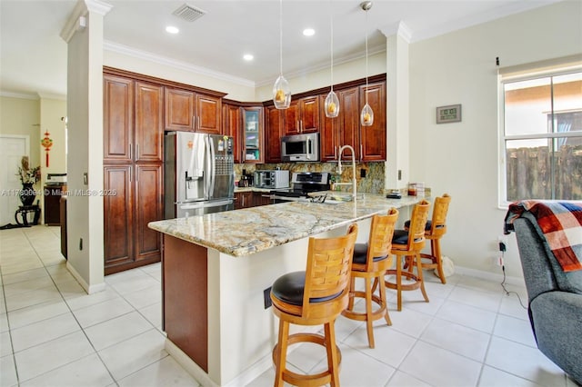 kitchen featuring light tile patterned floors, light stone countertops, a peninsula, visible vents, and stainless steel appliances