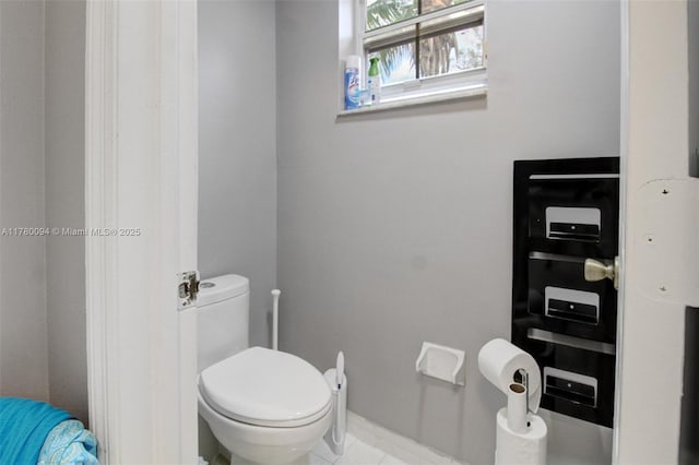 bathroom with toilet and tile patterned flooring