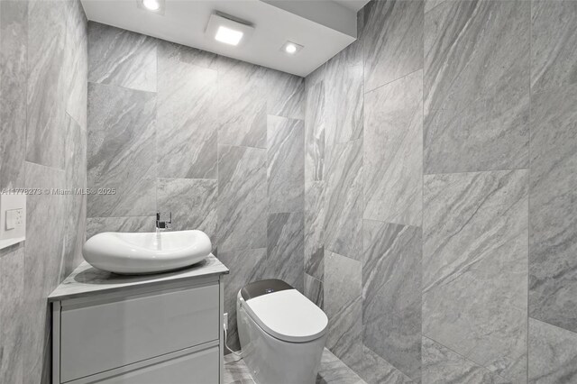 1658 Bay Rd Unit 504, Miami Beach, FL 33139 - bathroom with toilet, vanity, recessed lighting, and tile walls