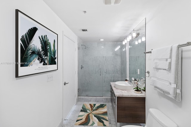 bathroom featuring vanity, toilet, a marble finish shower, marble finish floor, and visible vents