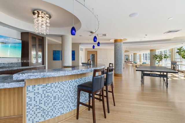 interior space featuring visible vents, decorative columns, and an inviting chandelier