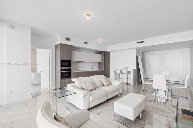 living area with visible vents, marble finish floor, and baseboards