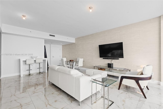 living room with marble finish floor, visible vents, and baseboards