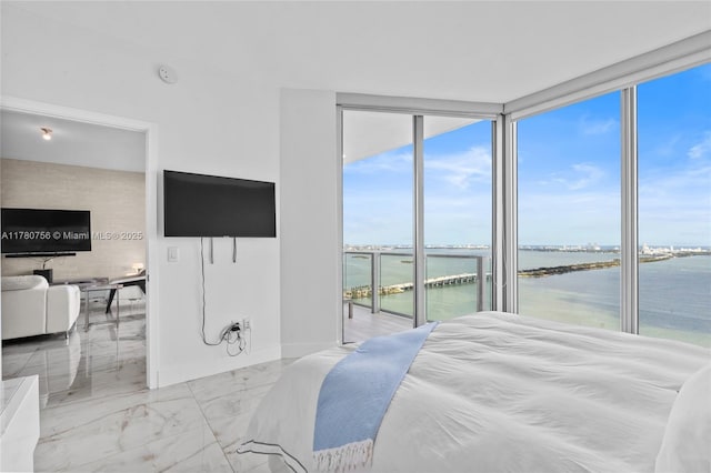 bedroom featuring expansive windows, marble finish floor, and access to outside