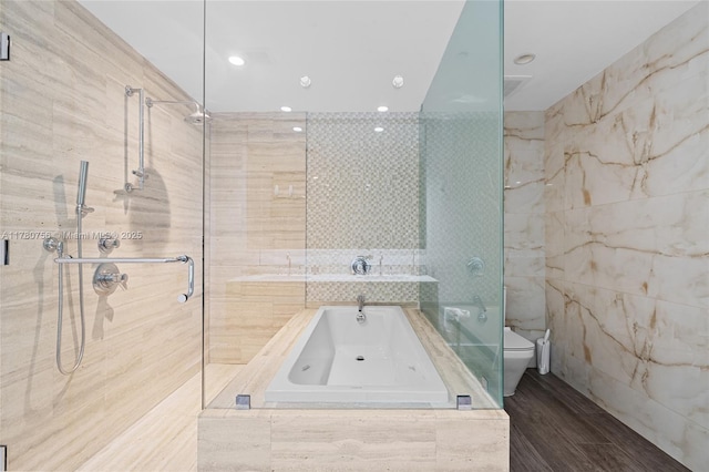 bathroom with recessed lighting, a tile shower, tile walls, toilet, and a bath