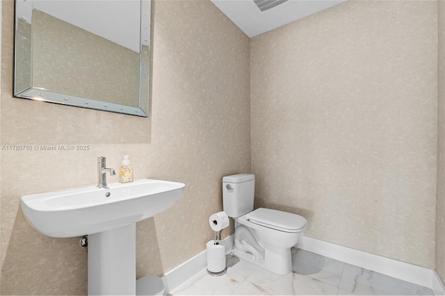 half bathroom featuring baseboards, visible vents, toilet, and marble finish floor