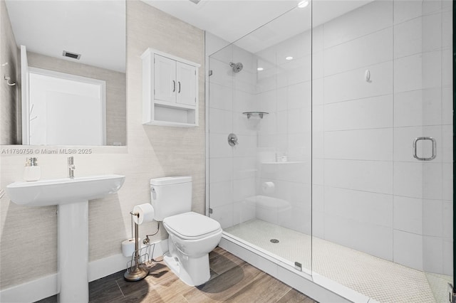full bathroom with toilet, a stall shower, visible vents, and wood finished floors