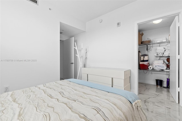 bedroom featuring a walk in closet, visible vents, marble finish floor, and a closet