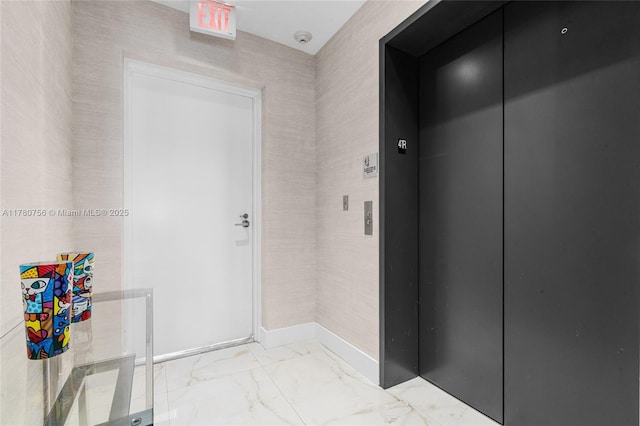 hall with baseboards, elevator, and marble finish floor