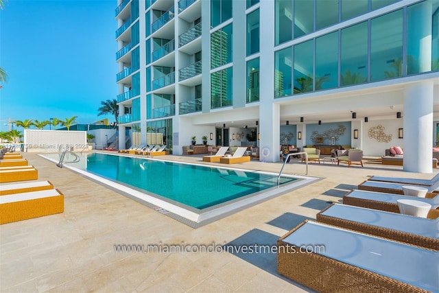 pool with a patio and an outdoor hangout area
