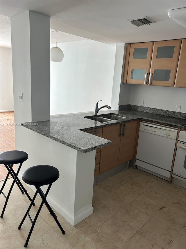 2101 Brickell Ave Unit 502, Miami, FL 33129 - kitchen featuring dishwasher, a peninsula, dark stone counters, and glass insert cabinets
