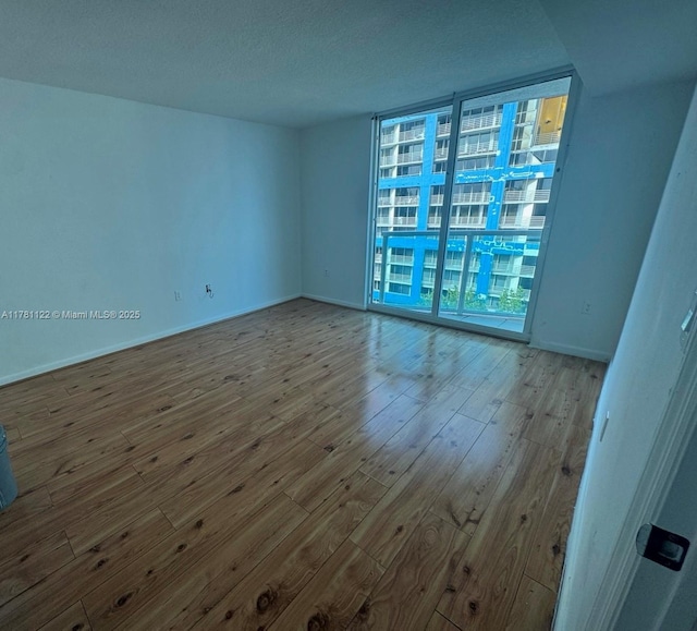 2101 Brickell Ave Unit 502, Miami, FL 33129 - spare room featuring hardwood / wood-style floors, floor to ceiling windows, and a textured ceiling