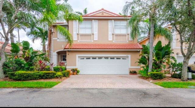 1410 Sweetbay Way, Hollywood, FL 33019 - mediterranean / spanish home featuring stucco siding, a tile roof, decorative driveway, and an attached garage