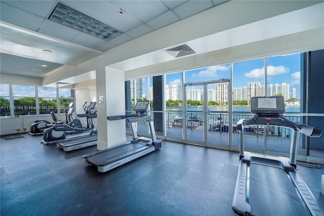 gym featuring a view of city, visible vents, and a paneled ceiling