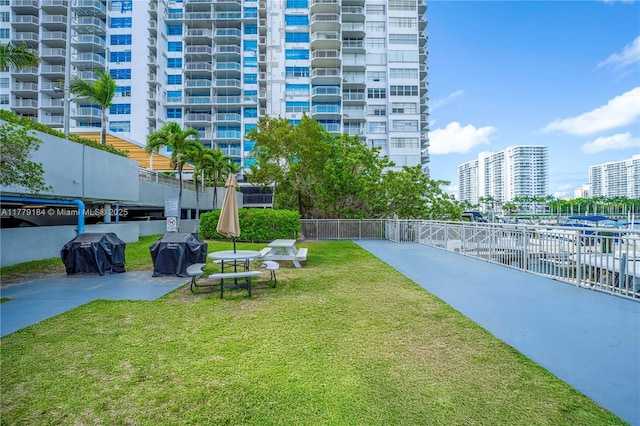 view of property's community with fence and a lawn