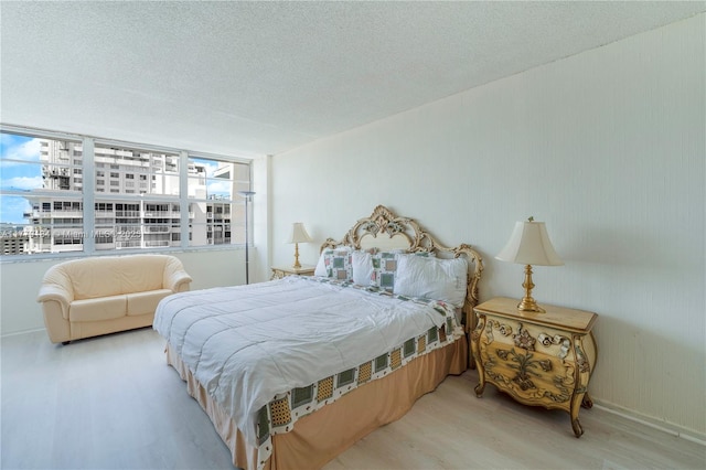 bedroom featuring a textured ceiling and wood finished floors