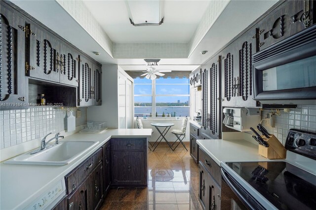 kitchen with electric range, ceiling fan, decorative backsplash, and a sink