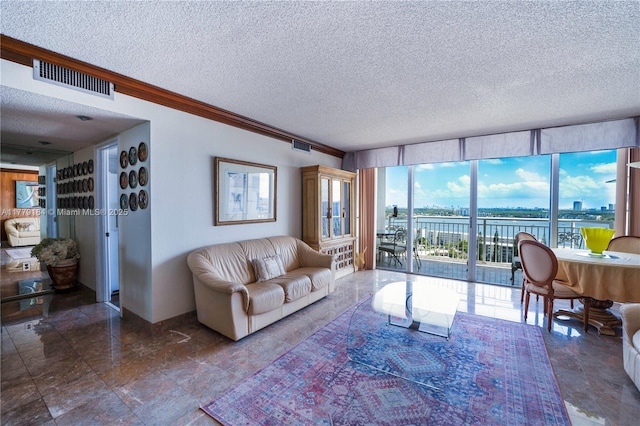 living area featuring visible vents, a water view, a textured ceiling, and crown molding