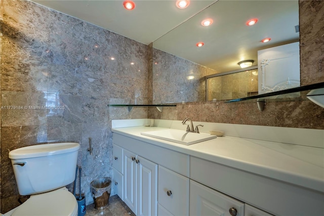 full bath with toilet, tile walls, and vanity
