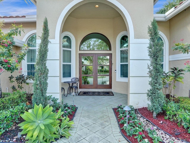 property entrance featuring french doors and stucco siding