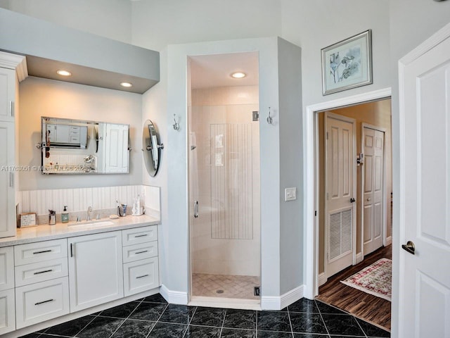 full bath featuring a shower stall, vanity, and baseboards