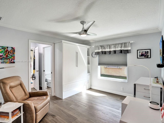 interior space featuring crown molding, a textured ceiling, a ceiling fan, visible vents, and wood finished floors
