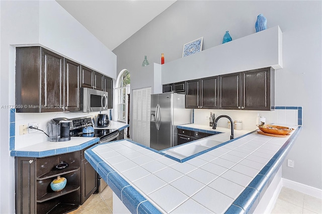 1008 NW 116th Ave, Coral Springs, FL 33071 - kitchen with appliances with stainless steel finishes, high vaulted ceiling, light tile patterned flooring, dark brown cabinetry, and a peninsula