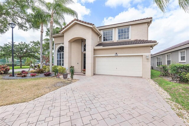 1008 NW 116th Ave, Coral Springs, FL 33071 - mediterranean / spanish-style house featuring stucco siding, decorative driveway, and a front lawn