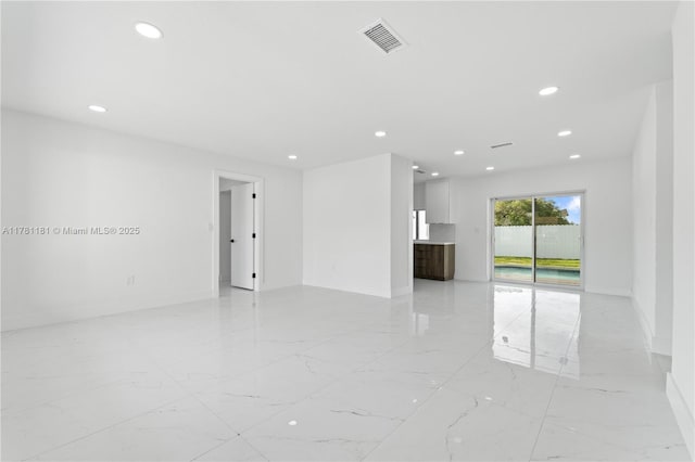 spare room featuring baseboards, recessed lighting, and marble finish floor
